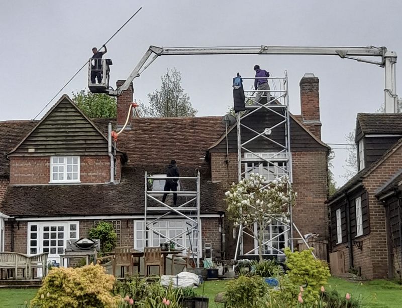 The Moss Cleaners using cherry picker and scaffolding to clean roof safely and professionally in Camberley, Surrey